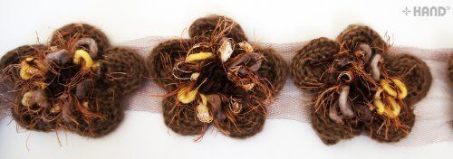 Close-up of decorative soft knitted flower net trim in brown