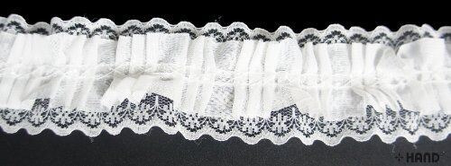 Roll of black elastic lace trim on a white background