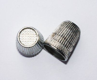 Close-up of a Slip-Stop silver finger tip thimble showing its 16mm diameter.