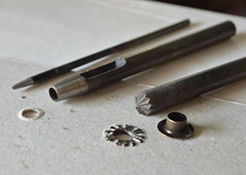 Eyelet openers in use on a piece of cardstock.