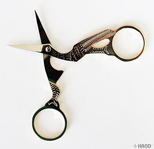 Stork embroidery scissors displayed on a crafting table.