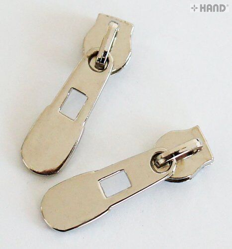 Silver polished zip pull attached to a fabric swatch.