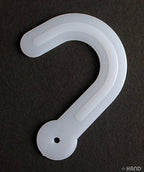 Close-up of a white plastic hanger designed for fabric samples.