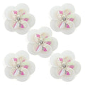 Large white round sequin and diamante flower trim on fabric.