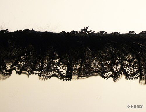 Black rabbit fur lace trim displayed on a crafting table