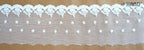 Close-up of white embroidered tulle lace edging on a craft project.