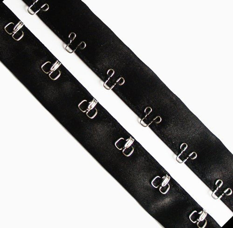 Close-up of silver hook and eyes on black silk ribbon