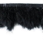 Close-up of black goose feather fringe trim on a white background.