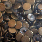 Silver 4-part flat top press stud buttons on a fabric