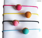 All four pairs of pastel ball hair bands on a flat surface.