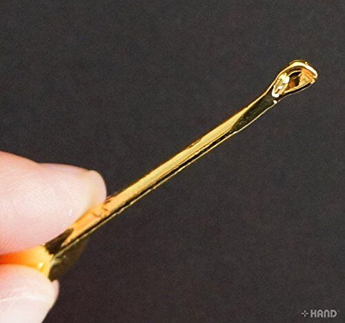 Metal earpicks held in hand to demonstrate size and usability.