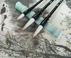 Both Sumi brushes arranged together with ink and paper