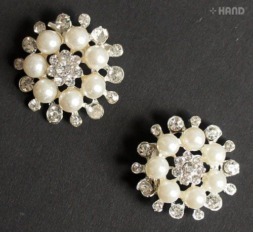 Two elegant pearl and clear crystal brooches displayed together.
