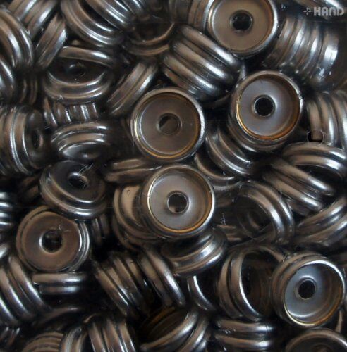 Silver press stud buttons used in a sewing project on fabric.