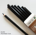 Twelve black charcoal sketching pencils arranged neatly