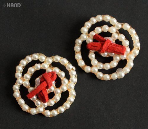 Two elegant pearl brooches displayed on a white background.