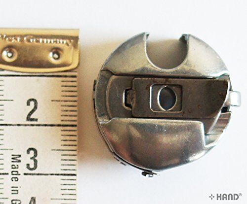 Different angles of the large Towa bobbin case for sewing.