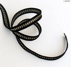 Close-up of black and gold velvet ribbon texture.