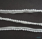 Close-up of tiny white pom pom trim showing 3mm pom poms
