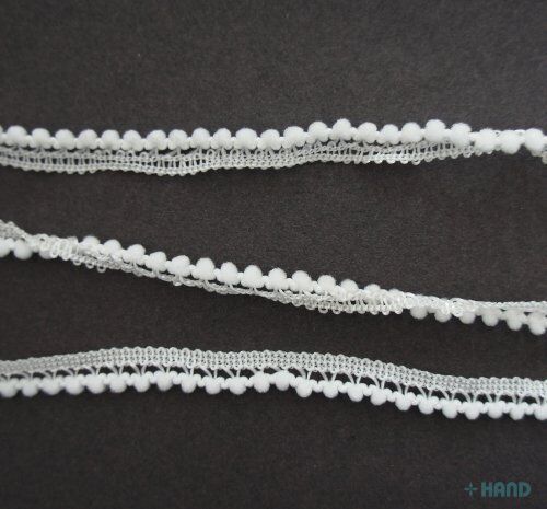 Close-up of tiny white pom pom trim showing 3mm pom poms