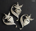 Three elegant crystal pearls silver brooches displayed together.