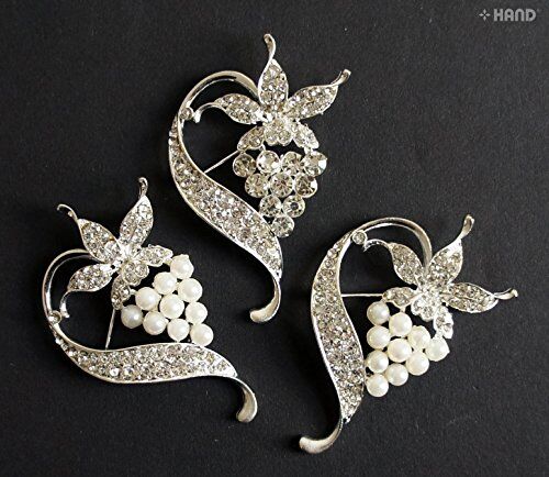 Three elegant crystal pearls silver brooches displayed together.