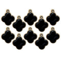 Black enamel four petal flower embellishment on a white background.