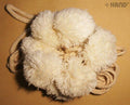 Off white decorative acrylic pom poms displayed together