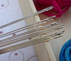Sewing needles displayed on a fabric background