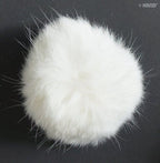 Close-up of a white rabbit bobble ball trim showing its fluffy texture.