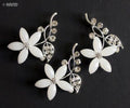 Three clear crystal and silver flower brooches displayed together.