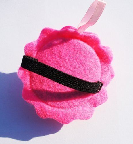 Close-up of a pink wrist pin cushion with pins inserted.