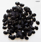 Close-up of black oval hotfix diamante gems showing their shine.