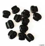 Black plastic toggle spring stop cord lock in use with string