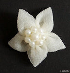 Close-up of a white flower trim featuring pearls.