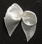 Assorted small decorative ribbon bows in white, pink, and red