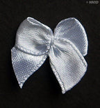 Assorted small white butterfly ribbon bows arranged for display
