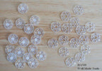 Close-up of a 15mm clear plastic clip button showing its design.