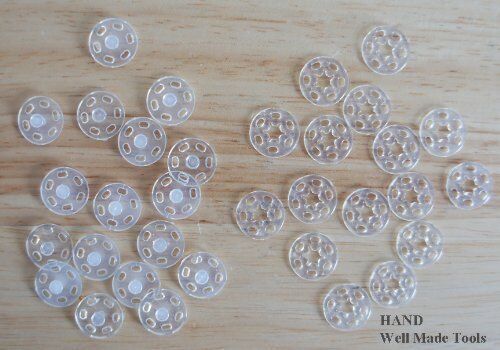 Close-up of a 15mm clear plastic clip button showing its design.