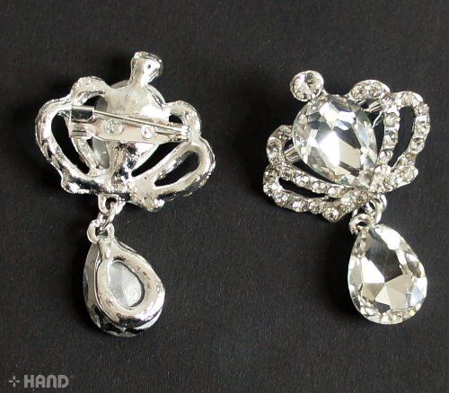 Brooches arranged on a fabric surface, highlighting their sparkling finish.