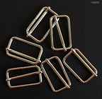 Display of silver tone metal sliders arranged neatly.