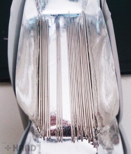 Different sizes of sewing needles displayed for comparison