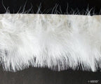 White goose feather fringe trim displayed on a crafting table.
