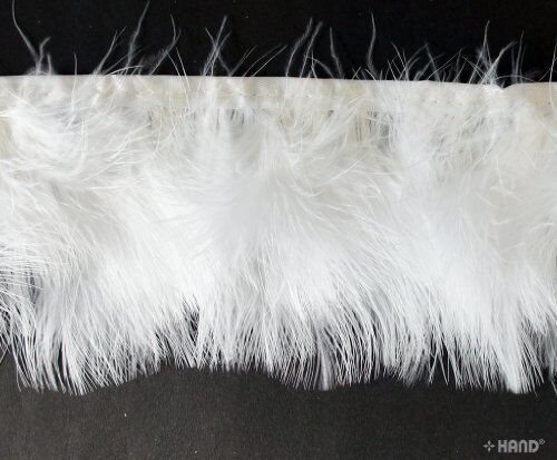White goose feather fringe trim displayed on a crafting table.