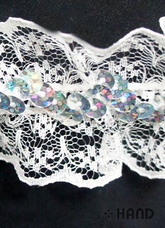 Nylon sequin lace elastic trim displayed on fabric