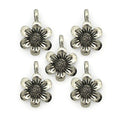 Five silver metal flower pendants on a white background.