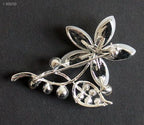 Close-up of a clear crystal flower brooch with silver accents.