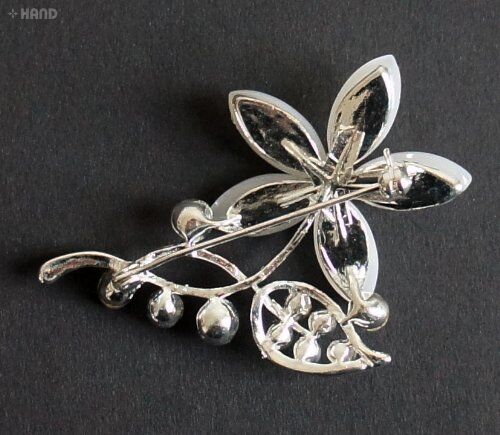 Close-up of a clear crystal flower brooch with silver accents.