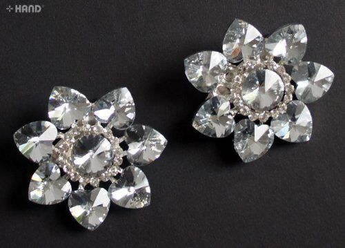 Two vintage crystal clear stone flower brooches displayed together.