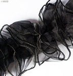 White chiffon frilly trim displayed on a crafting surface.